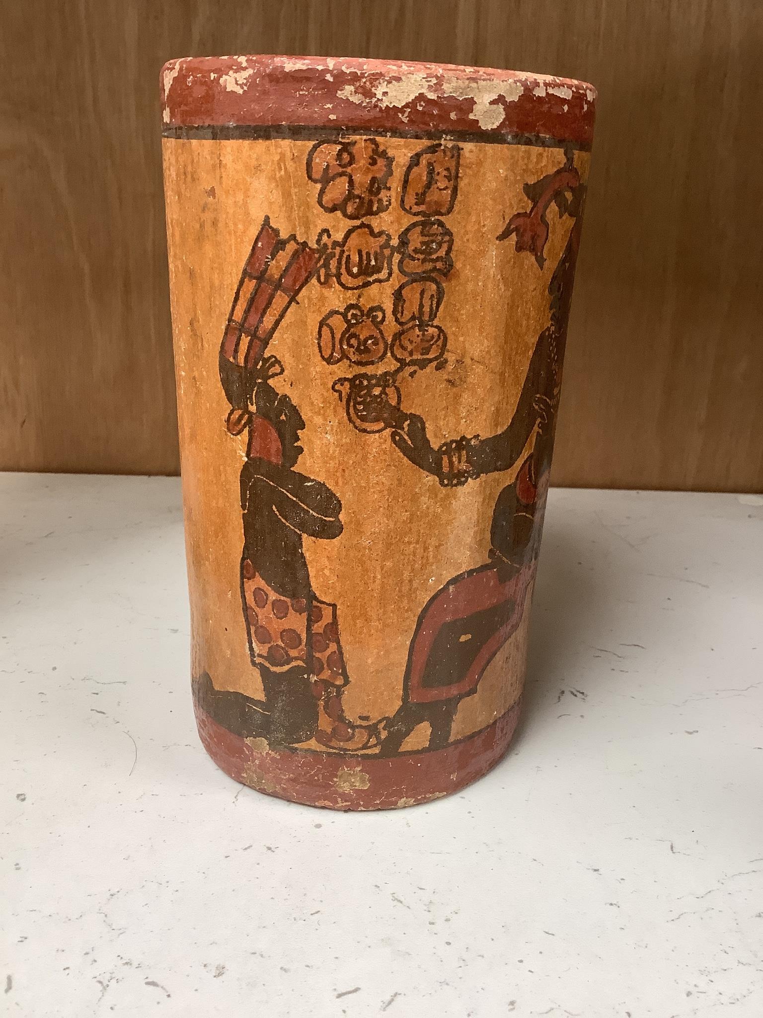 A Mayan pigment painted terracotta cylindrical vessel, possibly 7th-9th century AD., 17.2cm high, under a glass dome with revolving wood stand, total height 26cm